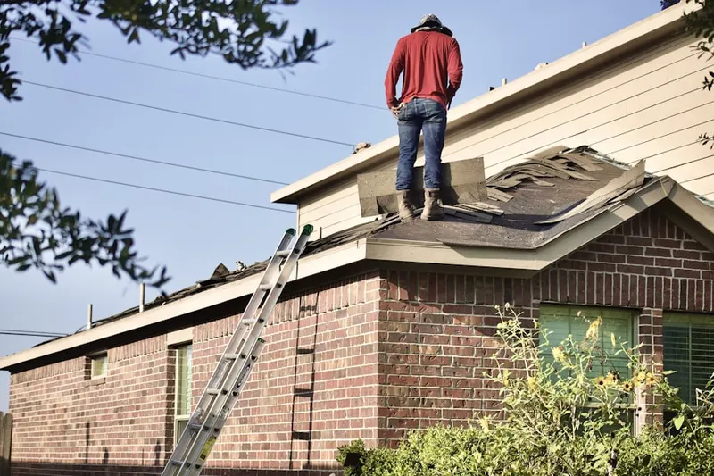 Professional roofer working on a residential roof in West Greenwich